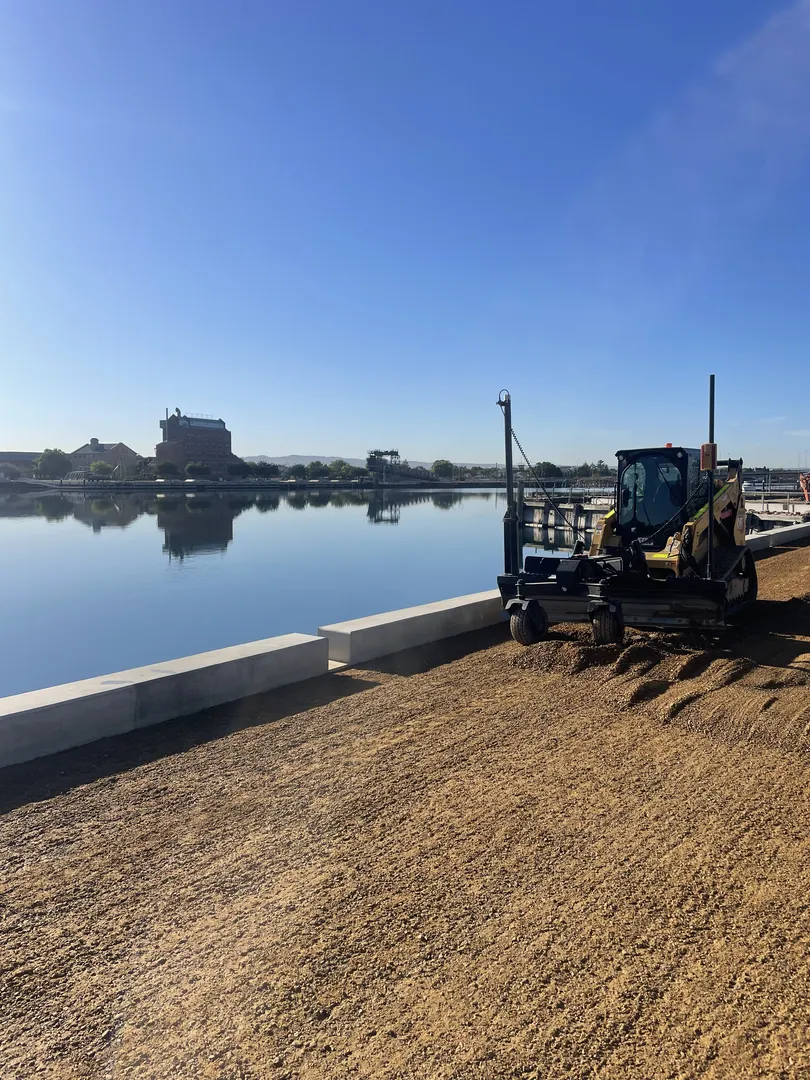 Construction vehicle near waterfront on sunny day